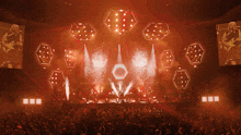 a large crowd of people watching a concert with a large screen behind them
