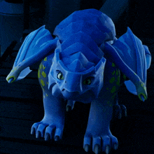 a blue dragon with green spots on it 's wings