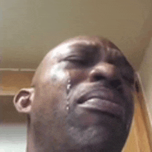 a close up of a man 's face with tears running down his face .