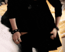a woman in a black dress is sitting on the floor with her head down