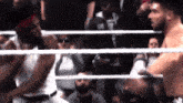 two men in a boxing ring with one wearing a shirt that says ' on ' on it