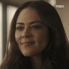 a close up of a woman 's face with a max logo in the background