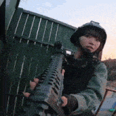 a woman in a helmet is holding a gun