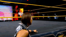 a woman in a wrestling ring with the word nxt on the bottom right