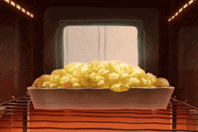 a casserole dish filled with macaroni and cheese is being cooked in an oven