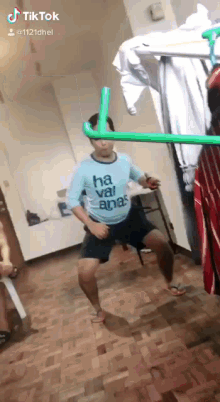 a man wearing a shirt that says ' ha vai anas ' is dancing in a room .