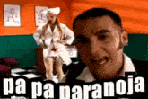 a man is standing in front of a woman in a nurse 's outfit and the words pa pa paranoja are above him .