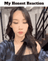 a woman is taking a selfie with her eyes closed and the words `` my honest reaction '' above her .