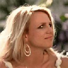 a close up of a woman 's face wearing hoop earrings .
