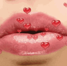 a close up of a woman 's lips with red hearts coming out of them