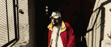 a man wearing a red jacket and a white hat with a tommy hilfiger logo