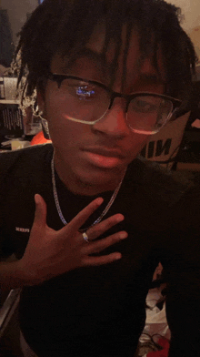 a young man wearing glasses and a black shirt that says ' xerox ' on it