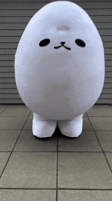 a white stuffed animal with a black nose and mouth