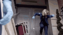 a woman in a blue jacket is running down a set of stairs with a stretcher .