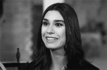 a black and white photo of a smiling woman .