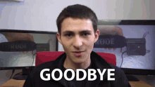 a young man says goodbye in front of a monitor