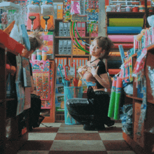 a woman kneeling down in a store with a sign that says ' sds ' on it