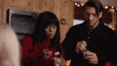a man and a woman are sitting in a kitchen eating