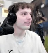 a man wearing headphones is sitting in front of a microphone .