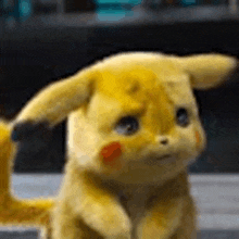 a close up of a yellow stuffed animal with a sad look on his face .