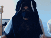 a woman wearing a black mask and bunny ears