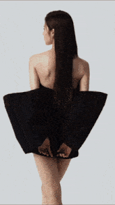 a woman in a black dress with a necklace on her neck