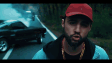 a man wearing a red hat is standing on a road