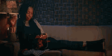 a woman is sitting on a couch with her legs crossed and listening to music .