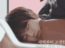 a person laying on a bed with asian writing on the bottom right