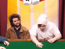 a man in a white hat is playing a game of chess