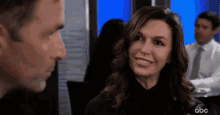a man and a woman are looking at each other in a room .