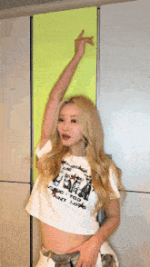 a blonde woman wearing a white crop top that says ' violence to all ' on it