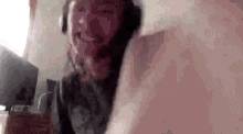 a woman wearing headphones is making a funny face while sitting on a bed .