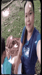 a woman wearing a blue shirt that says ozone is taking a selfie
