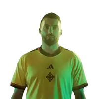 a man wearing a yellow adidas shirt stands in front of a green background