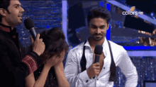 a man is holding a microphone in front of a woman and the words colors hd are on the screen
