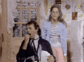 a man is yawning while a woman holds a piece of paper in front of him .