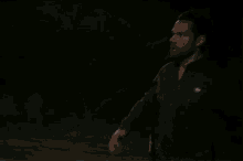 a man in a dark room with a badge on his chest that says ' u.s. army ' on it
