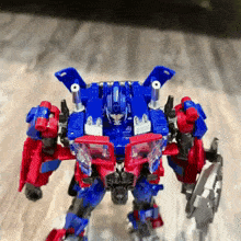 a blue and red robot with a shield and guns