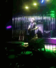 a blurry picture of a man playing a guitar on stage
