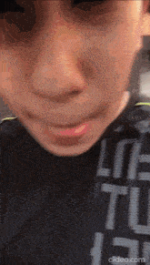 a close up of a person 's face with a shirt that says life to the left