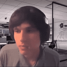 a man wearing headphones looks at the camera with a blurred background