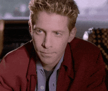 a man wearing a red jacket and a blue shirt