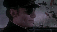 a man wearing sunglasses and a hat looks at something