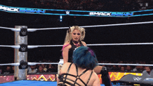 two women in a wrestling ring with a banner that says bmack down