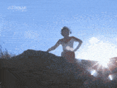 a silhouette of a man standing on a rock with the word ultraman on the bottom right