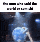 the man who sold the world or sum shi is pushing a large blue balloon