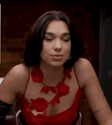 a woman in a red dress has a tattoo on her arm