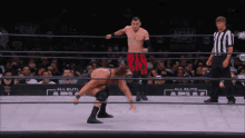 a wrestler in a ring with a aew logo on the wall