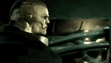 a man wearing a headset is standing in a dark room .